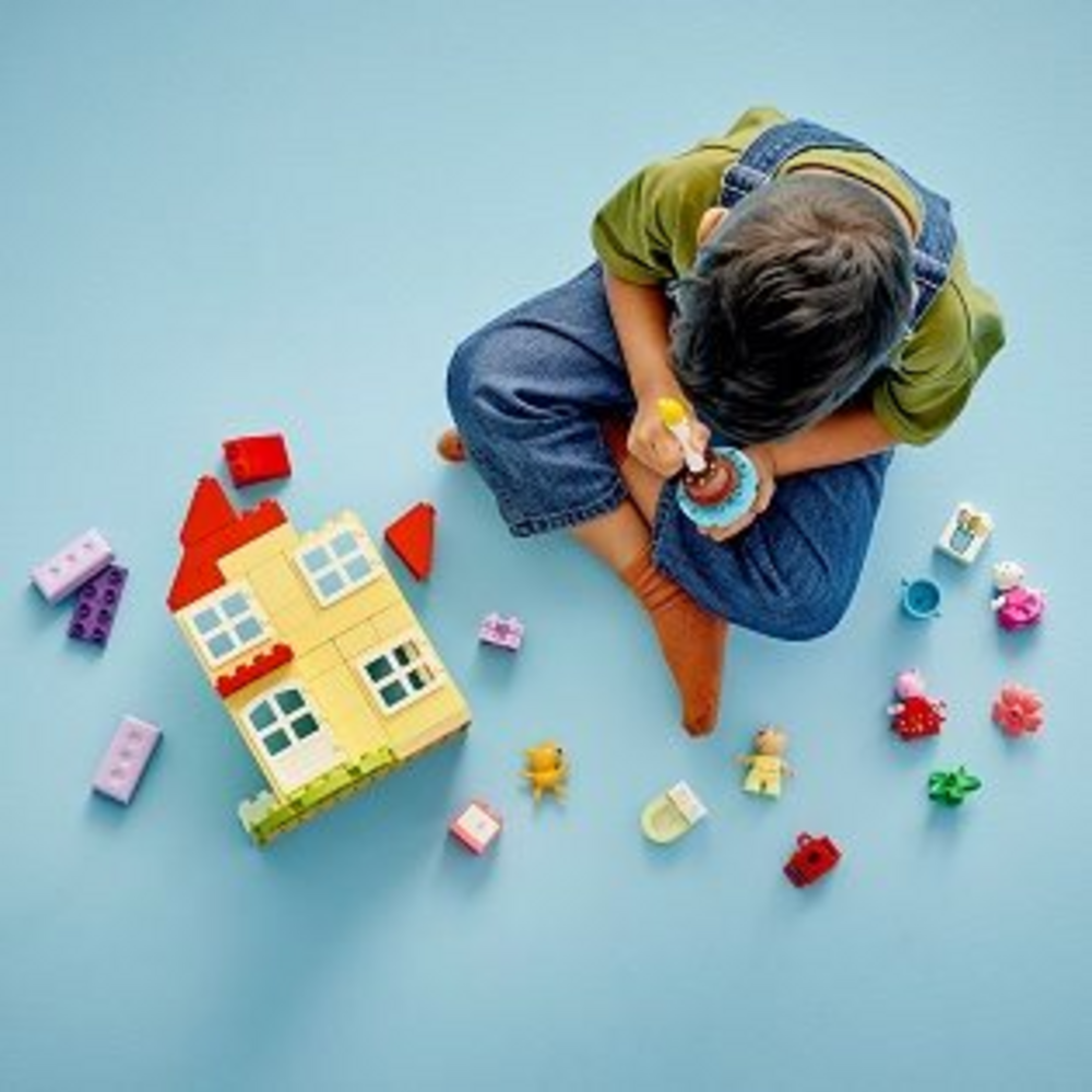 Dítě staví LEGO DUPLO narozeninový dům s doplňky