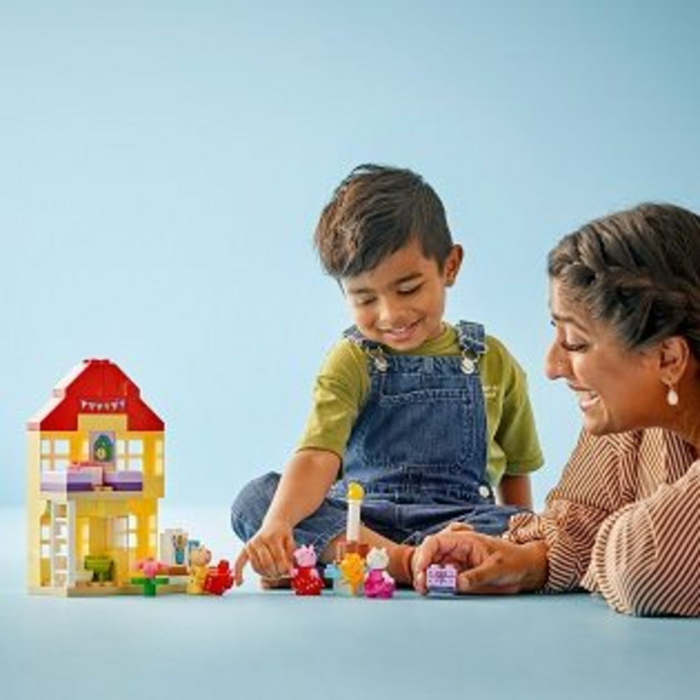 Dítě a dospělý si hrají s LEGO DUPLO Prasátko Peppa a narozeninový dům